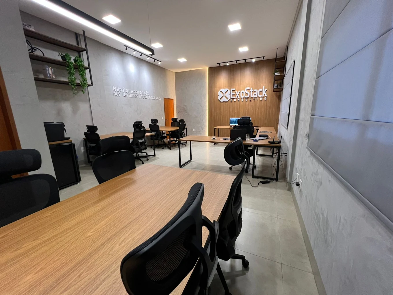 Sala de trabalho da ExoStack com a marca na parede